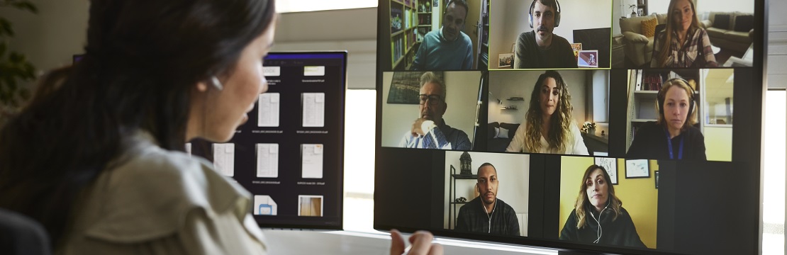 Woman sits in front of a computer on a video conference call. 